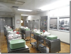 上菅田特別支援学校：給食配膳室。教室毎の食器が入ったかごの中にはきざみ用のハサミも。