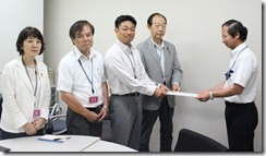 神奈川労働局中川賃金室長（右）に最低賃金についての申し入れ書を手渡す日本共産党県・市議団（左側）